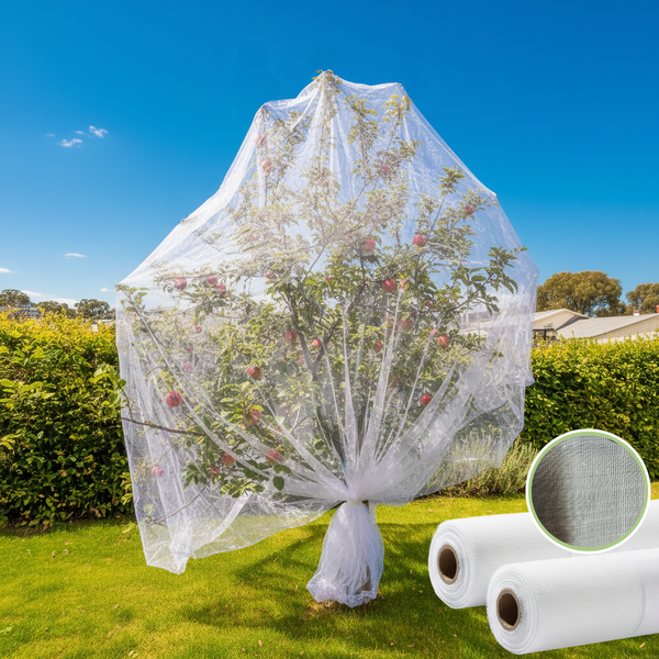 Tree wrapped in protective plastic sheet with two rolls of similar material on grass.