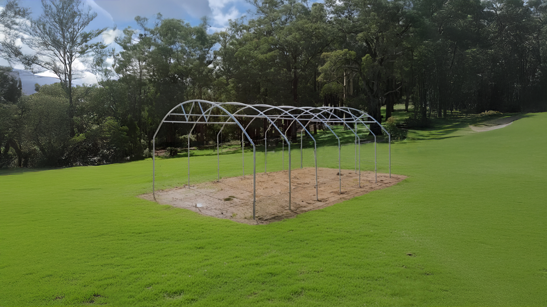 frame structure on a grassy area with trees in the background