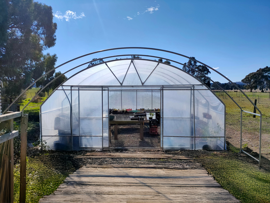 greenhouse with tables in side  blue sky