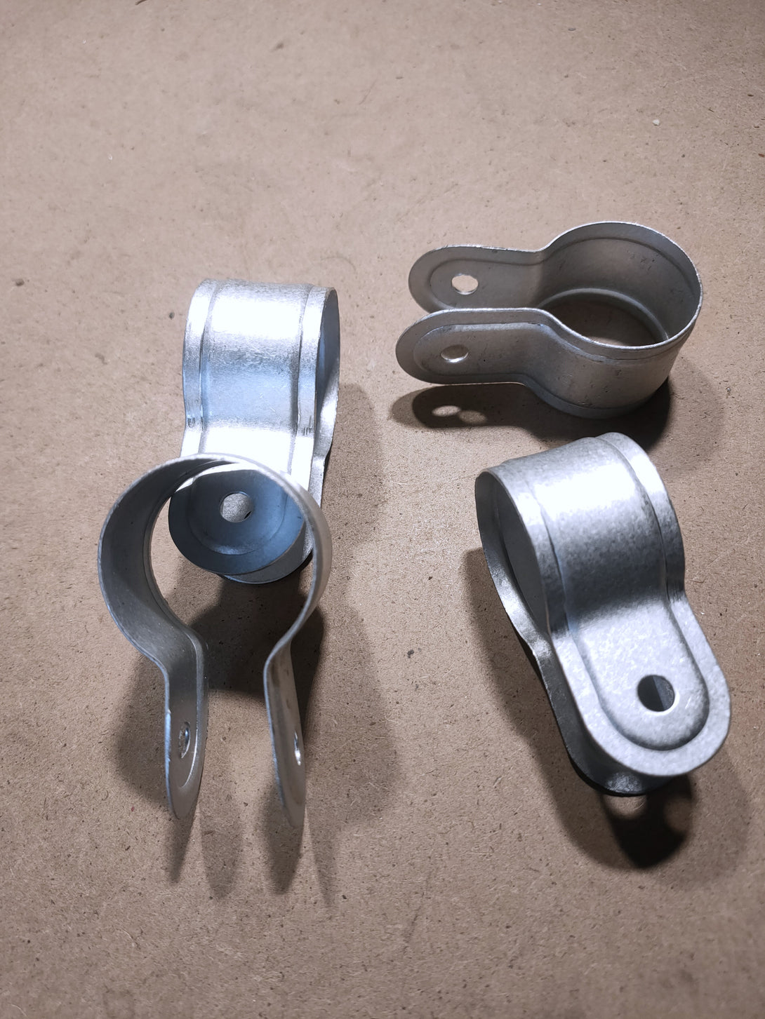 Three metal clamps on a brown surface